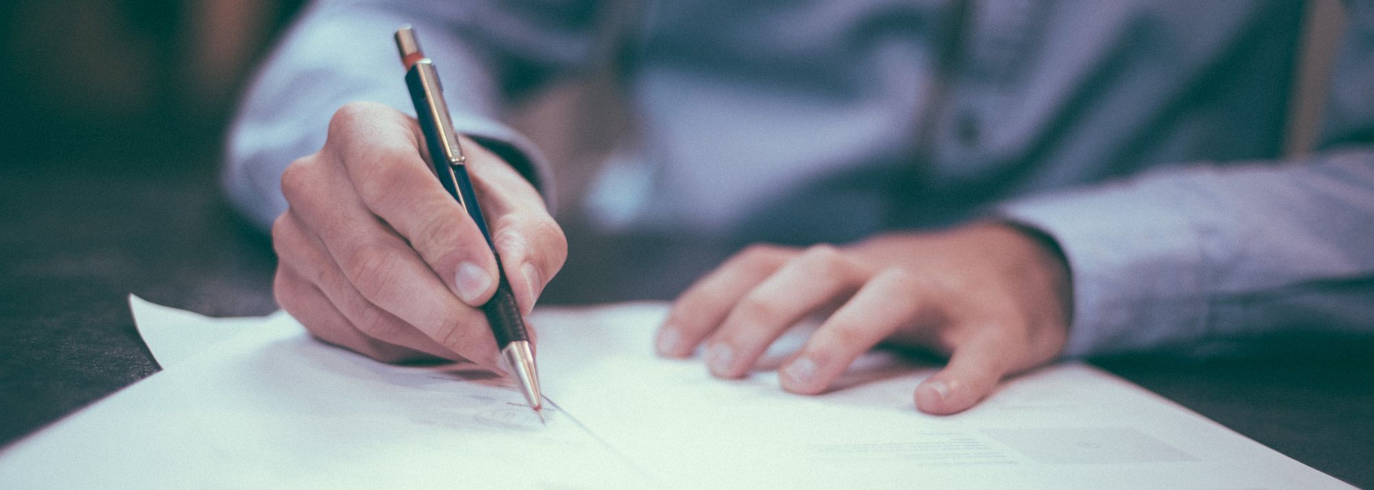 Image of man writing with a pen